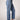 Blue Revival Beau button down jeans in Ora with gold buttons along each side and raw hem.