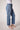 Blue Revival Beau button down jeans in Ora with gold buttons along each side and raw hem.