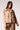Woman wearing the Blue Revival Charli cropped scuba trench in camel open, showing the fitted silhouette, oversized buttons and tie belt.