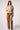 Woman wearing the Blue Revival Charli cropped scuba trench in camel with a cinched tie waist and fitted silhouette.