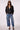 Woman wearing the Blue Revival Charli cropped trench coat in black open over a white top, showing the double-breasted front and cropped silhouette.