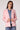 Woman wearing the Blue Revival Helen blazer in pale pink with removable denim insert and a fitted silhouette.