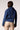 Blue Revival Lana cropped denim trench in Lisbon, back view showing the fitted cropped silhouette and belted cuffs.