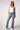 Woman wearing Blue Revival Maya mid-rise seamed bootcut jeans in Medium Tel Aviv, showing the fitted hip and flared bootcut leg.