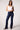 Woman wearing Blue Revival Maya mid-rise recycled bootcut jeans in Amsterdam dark wash with a fitted waist and bootcut silhouette.