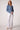 Woman wearing the Blue Revival Olivia cropped recycled denim blazer in medium wash with a fitted silhouette and silver buttons.