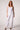 Woman wearing the Blue Revival Palazzo pants in white with a polished wide-leg silhouette.
