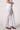 Blue Revival Palazzo pants in white, side view showing the mid-rise fit and flowing wide-leg shape.