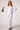 Woman wearing the Blue Revival Piper peplum jacket in white with a sculpted, fitted silhouette.