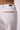 Close-up of the Blue Revival Sadie wide leg jeans in white showing the tan faux suede pocket detailing and stitching.