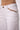 Close-up of the Blue Revival Sadie wide leg jeans in white showing the tan faux suede pocket detailing and stitching.