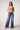 Woman wearing Blue Revival Selena mid-rise recycled wide-leg jeans in Prague, styled with a wide-leg trouser silhouette.